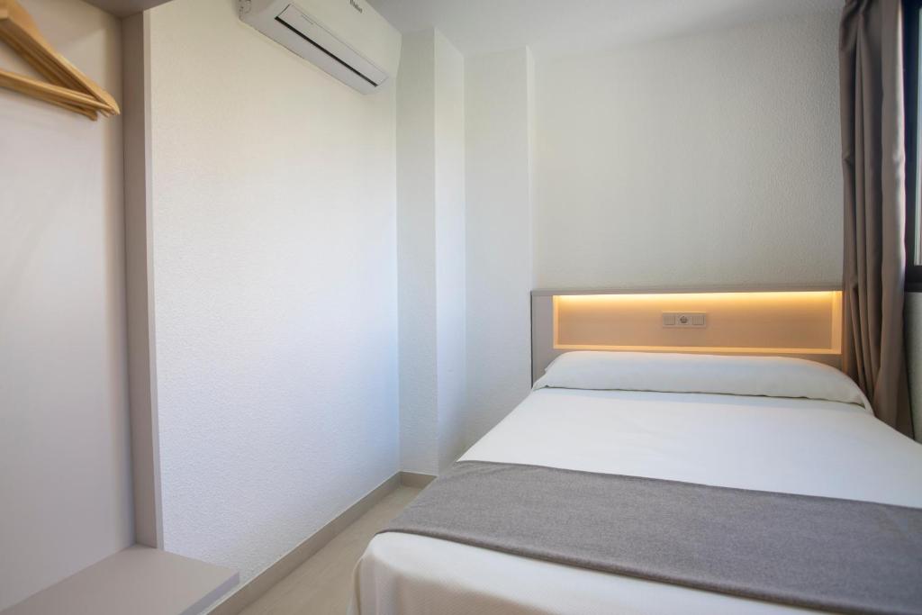 a small bedroom with a bed and a window at Aparthotel BCL Levante Club in Benidorm