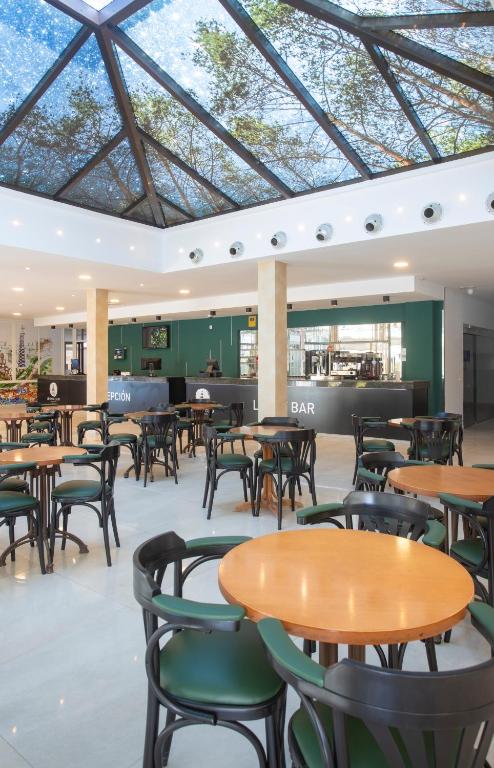a cafeteria with tables and chairs in a building at Aparthotel BCL Levante Club in Benidorm
