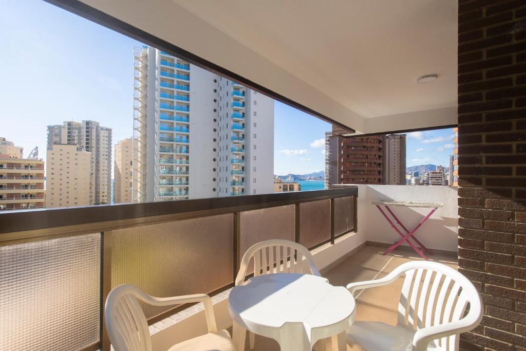 a balcony with a table and chairs and a view of the city at Aparthotel BCL Levante Club in Benidorm