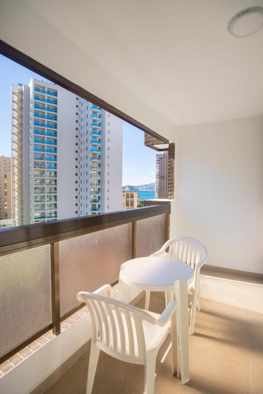 two white chairs and a table on a balcony at Aparthotel BCL Levante Club in Benidorm