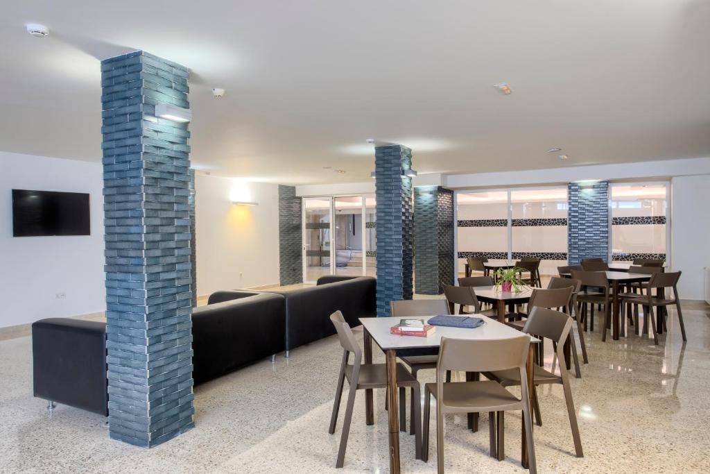 a dining room with tables and chairs and a couch at Aparthotel BCL Levante Club in Benidorm
