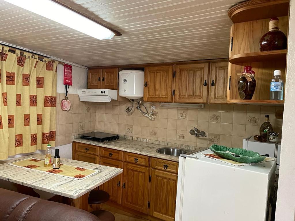 uma cozinha com armários de madeira e um frigorífico branco em Casa das bonecas em Castro Daire