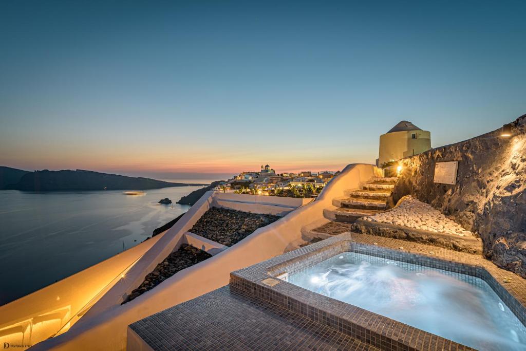 a hot tub on the side of a building with the water at Enalion Suites in Oia