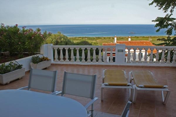 - un balcon avec deux chaises et une table donnant sur l'océan dans l'établissement Gerry&Lotti Apartment, à Son Bou