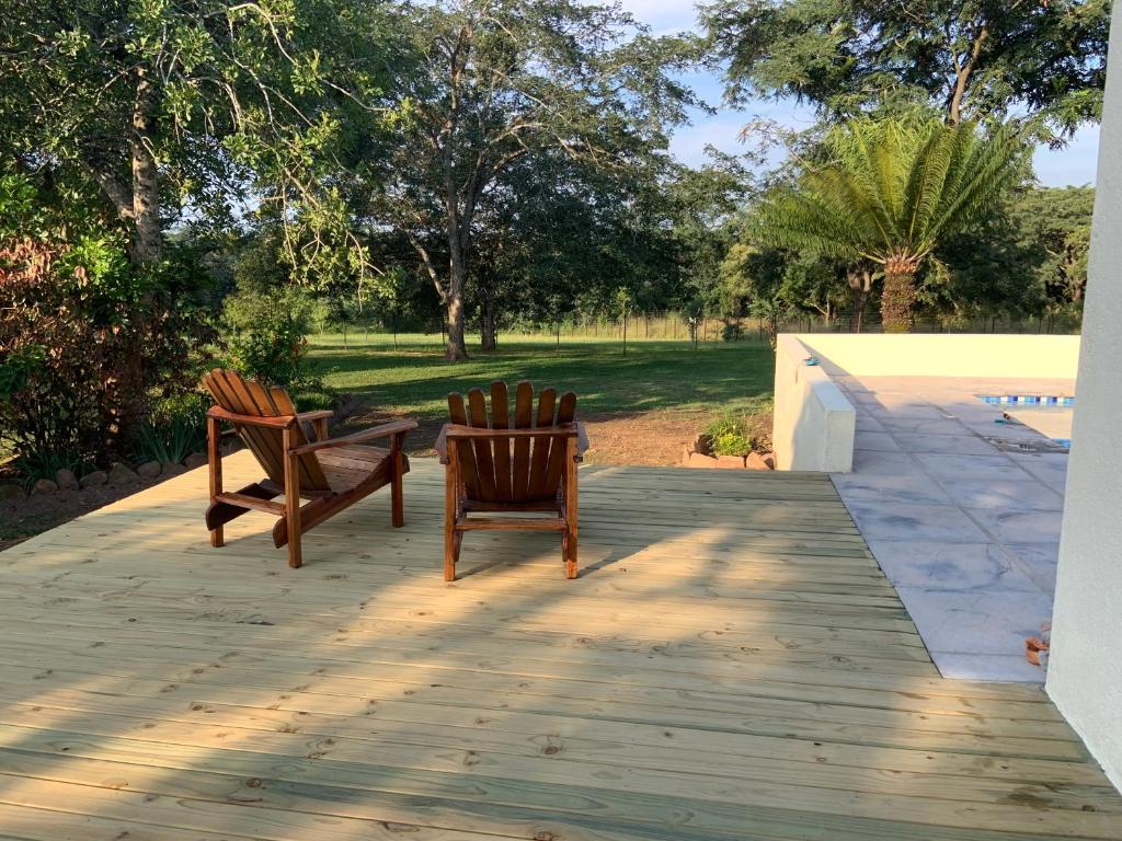 two chairs and a table on a wooden deck at Bergdale Cottages in Hazyview