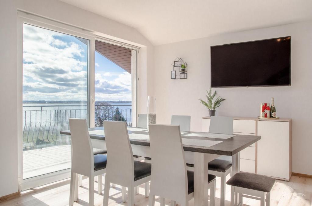 a dining room with a table and chairs and a large window at Duży apartament Mielno in Mielno