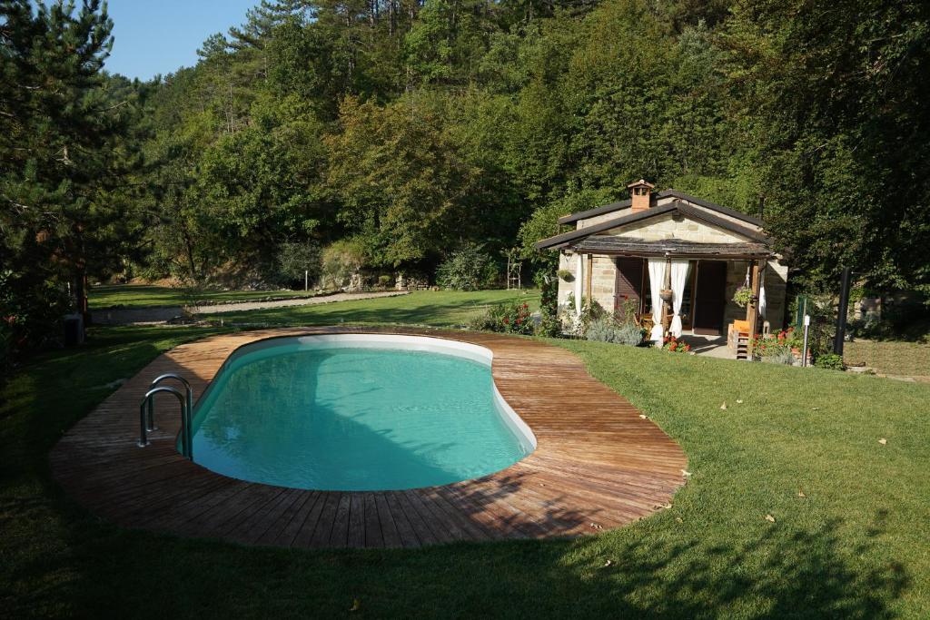 a swimming pool on a wooden deck next to a gazebo at Casa Camporino in Poppi