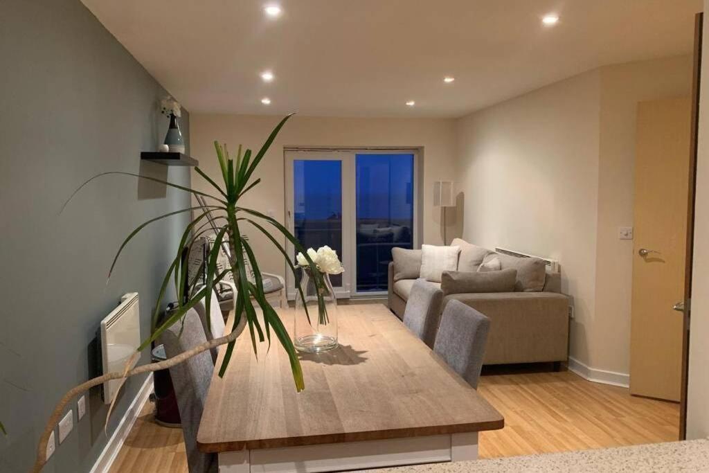 uma sala de estar com um sofá e uma mesa em Harbour Beach Apartment em Pevensey