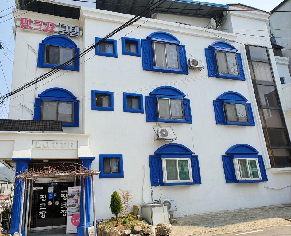 un edificio azul y blanco con ventanas azules en Healinghouse Peakjang, en Buyeo