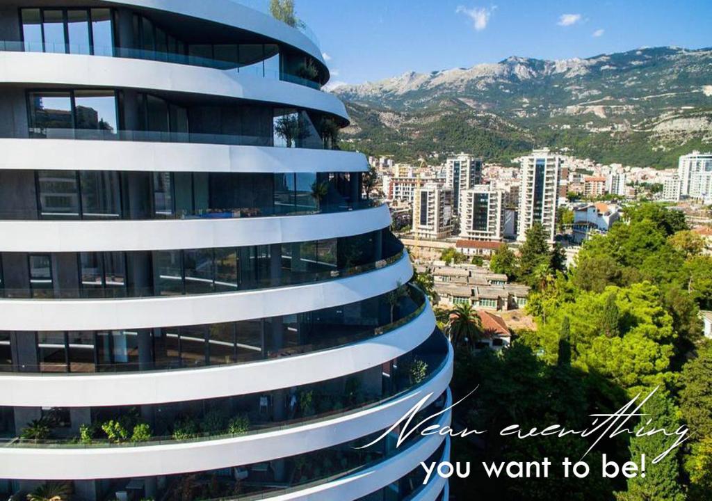 a tall building with a city in the background at Amare Luxury Apartments in Budva