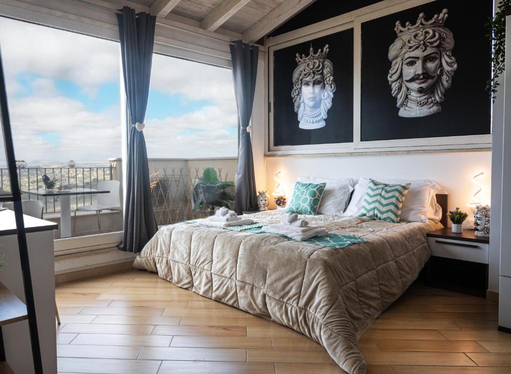 - une chambre dotée d'un lit avec deux masques sur le mur dans l'établissement Il Moro - Agrigento Rooms, à Favara