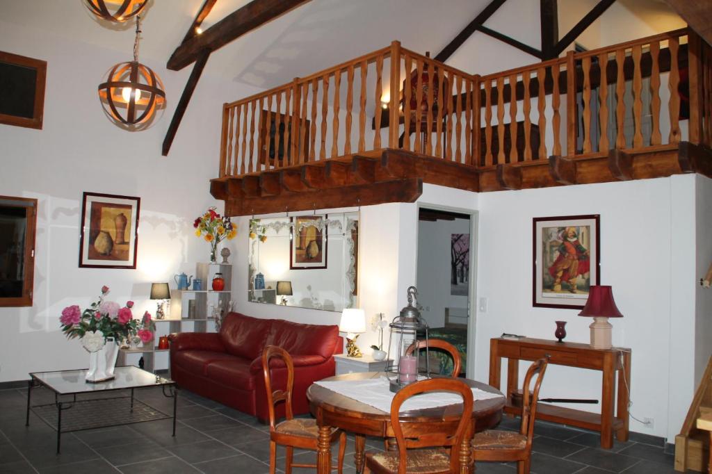 Jardin de Pomarède في Prigonrieux: غرفة معيشة مع أريكة حمراء وطاولة