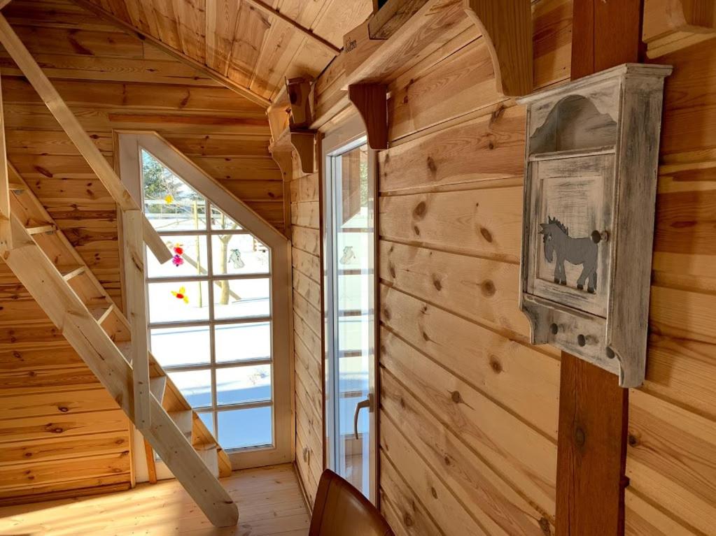 a staircase in a log cabin with a window at Toskania Kociewska in Nowe