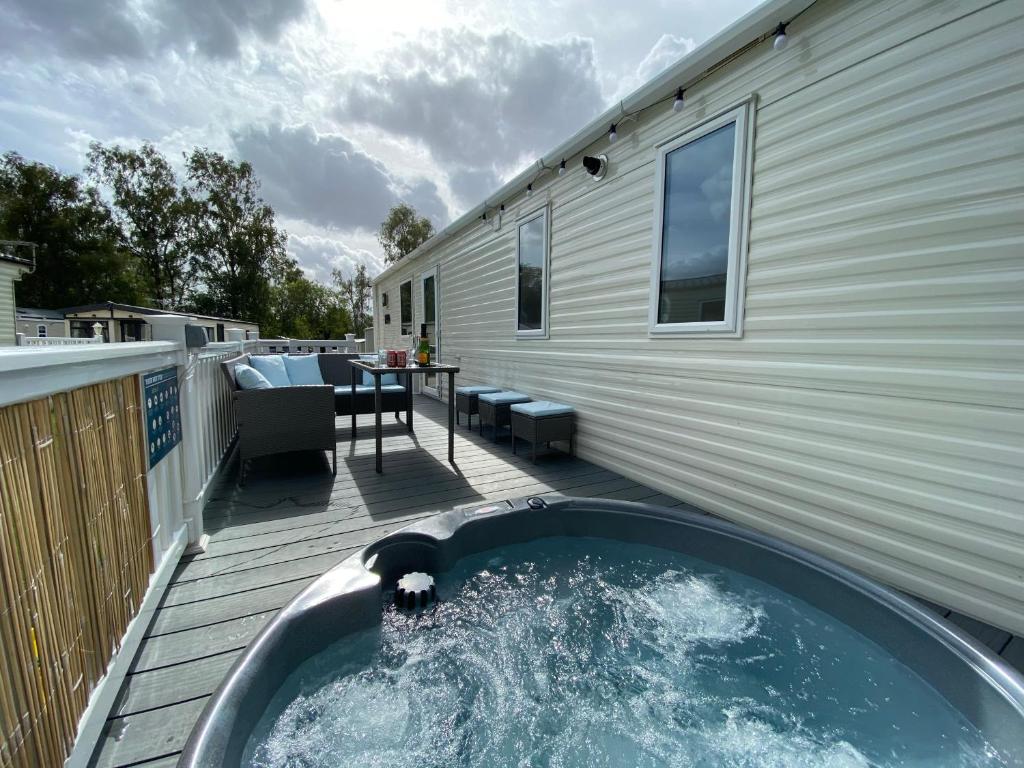 a hot tub on a deck next to a building at Lakes Breaks - 6 Meadows in Tattershall