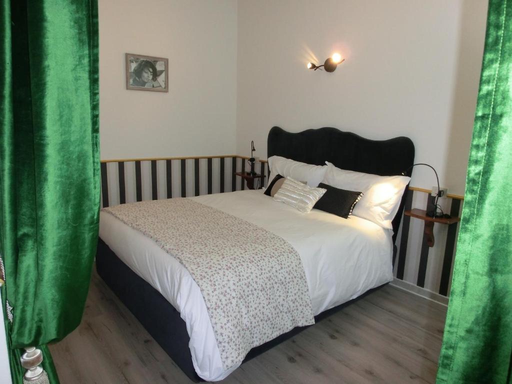 - une chambre avec un grand lit et des rideaux verts dans l'établissement Love and More House, à Imola