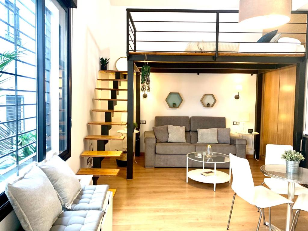 ein Wohnzimmer mit einem Sofa und einem Tisch in der Unterkunft Homely Malaga Refino Loft D4 in Málaga