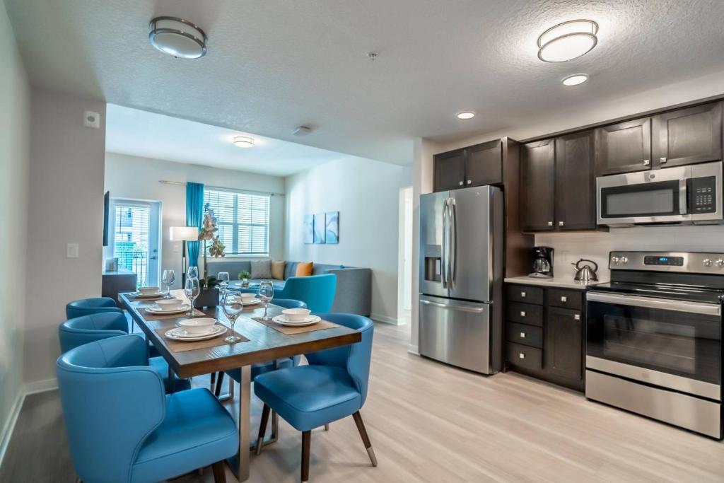 a kitchen and dining room with a table and blue chairs at 4013 Vista Cay 2 in Orlando