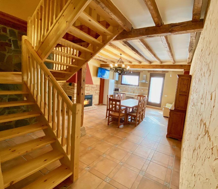 a wooden staircase in a living room with a table at La Parada de Jimena-Casa rústica rodeada de bodegas en Rueda in Rueda