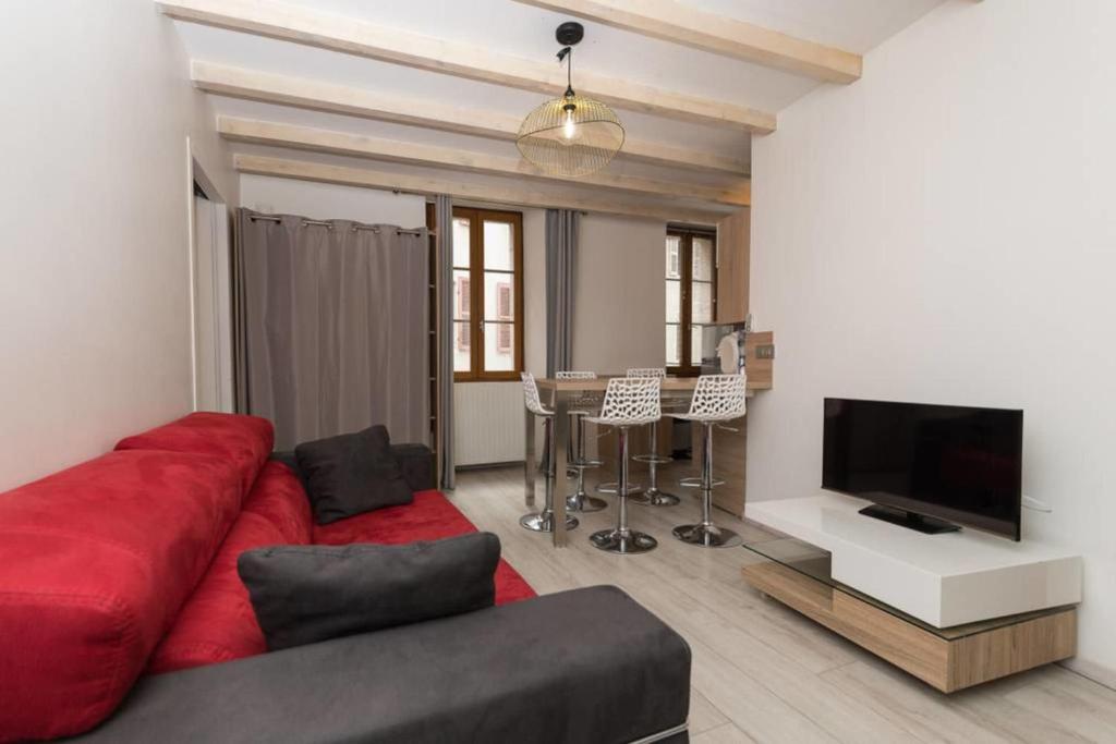 ein Wohnzimmer mit einem roten Sofa und einem TV in der Unterkunft La Tournette - Apartment for 2-4 people in the heart of the old town in Annecy