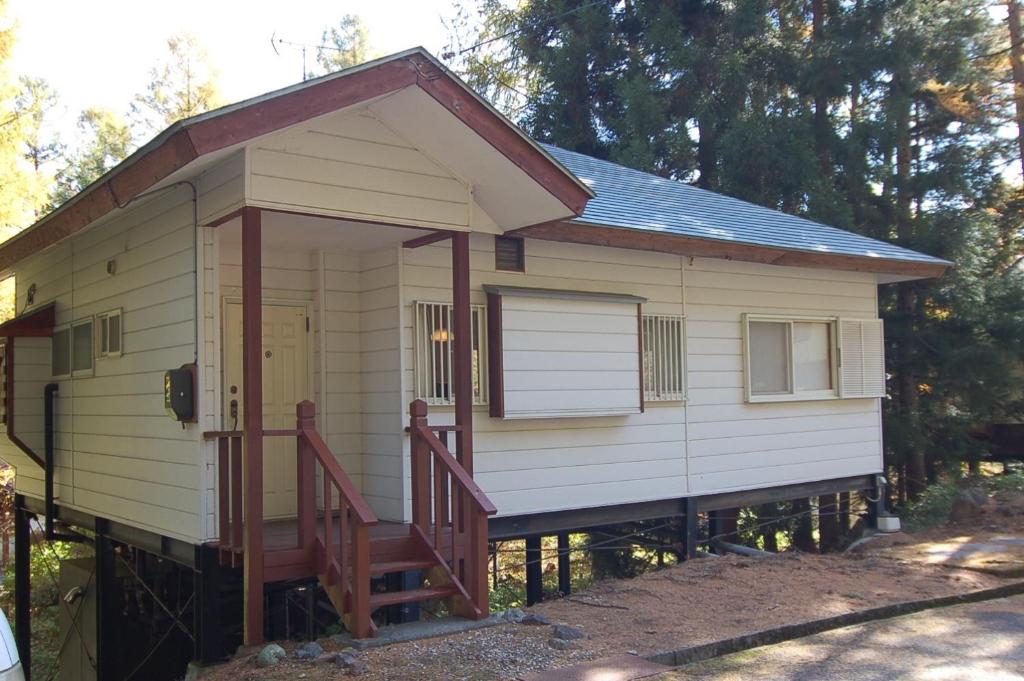 Cette petite maison blanche dispose d'une véranda et d'une porte. dans l'établissement Shakunagedaira Rental cottage - Vacation STAY 18352v, à Numanokura