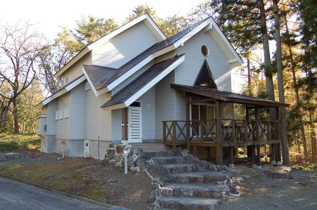 Cette petite maison blanche dispose d'une terrasse couverte et d'escaliers. dans l'établissement Shakunagedaira Rental cottage - Vacation STAY 18466v, à Numanokura