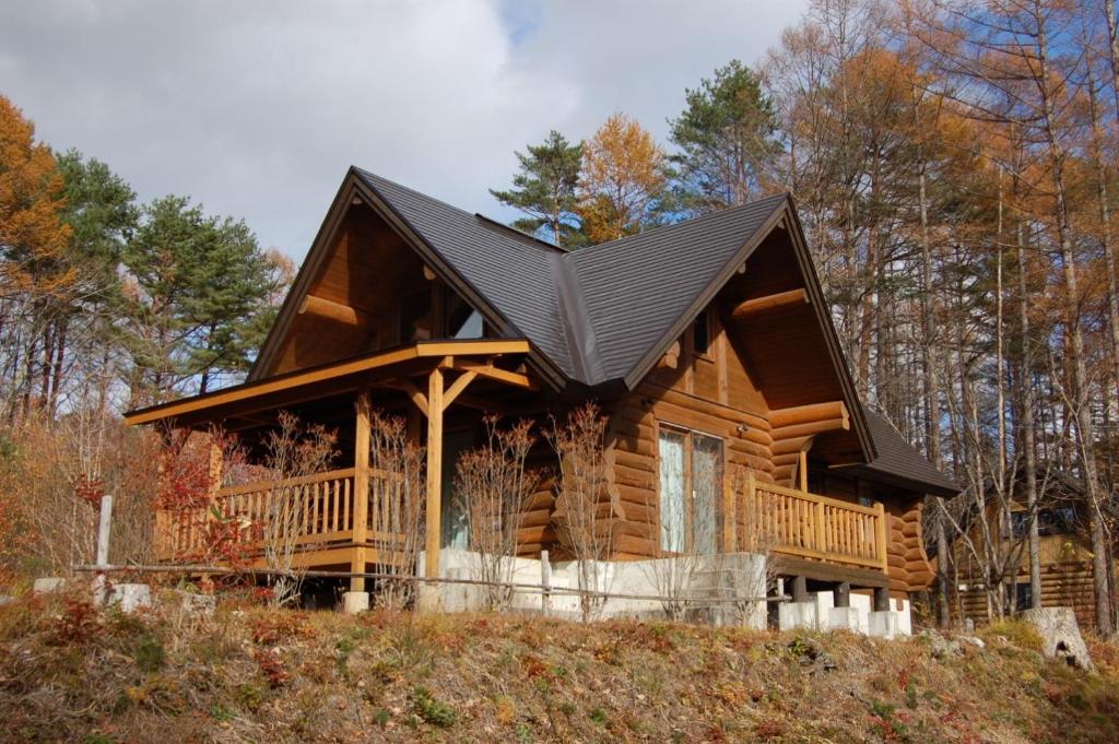 une cabine dans les bois avec un toit noir dans l'établissement Shakunagedaira Rental Cottage - Vacation STAY 18468v, à Numajiri