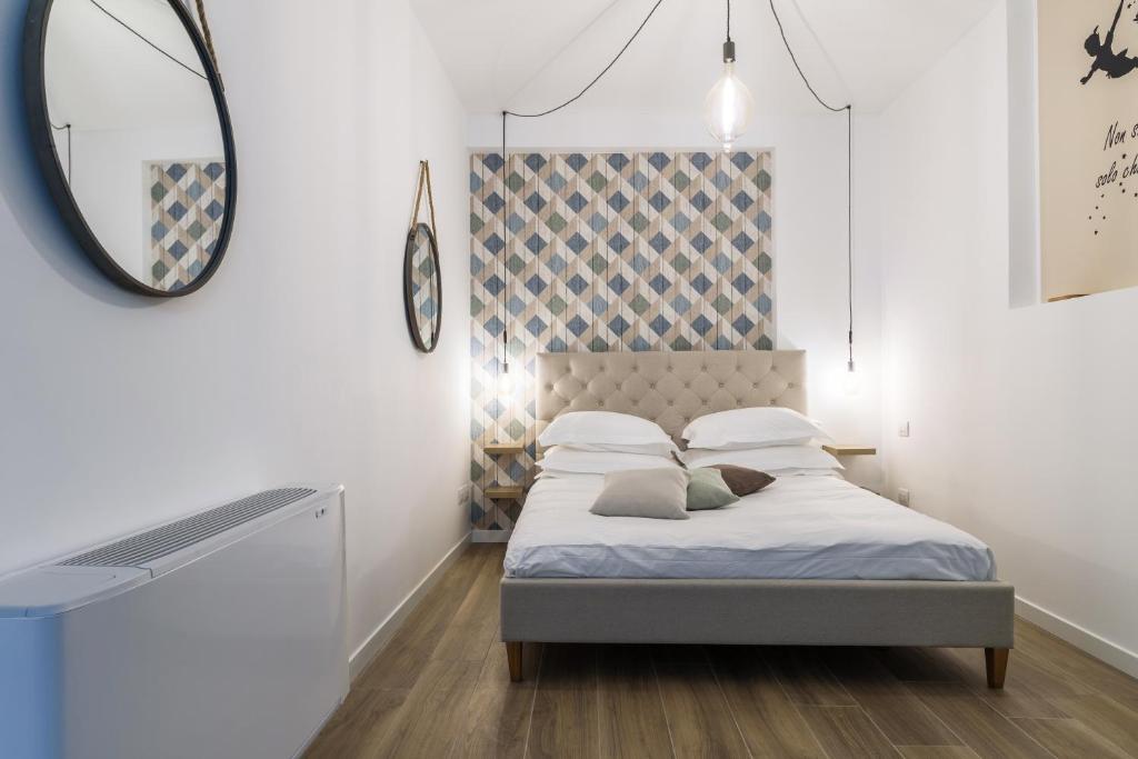 ein Schlafzimmer mit einem Bett mit einem Spiegel und einem Spiegel in der Unterkunft SPAZIO M&M CELLINI 3 in Mailand
