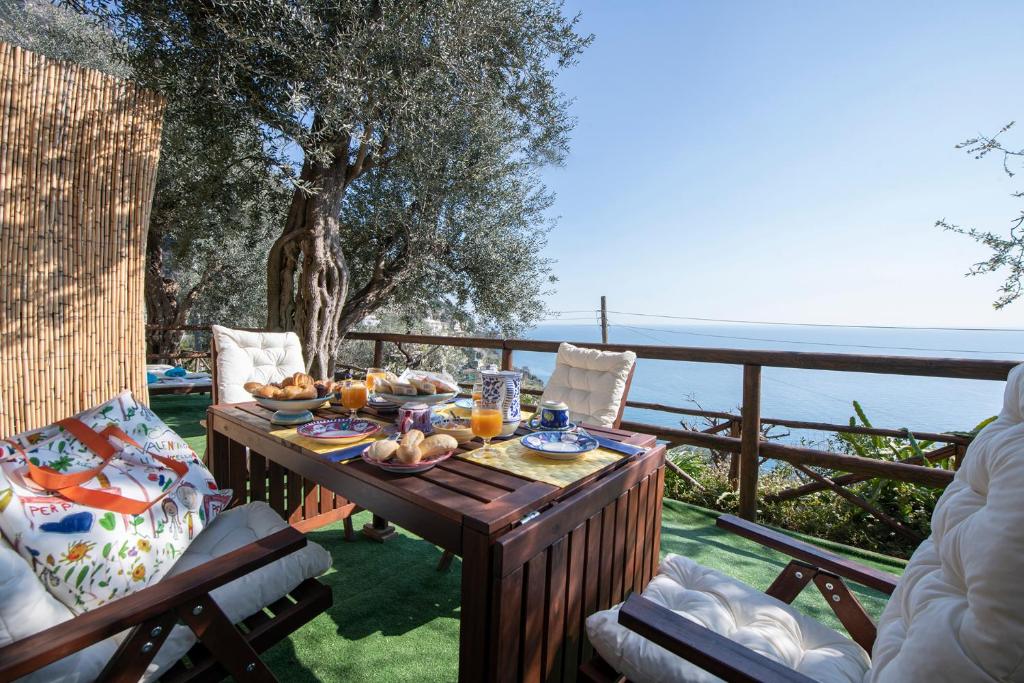 uma mesa com comida e vista para o oceano em Maison Don Rafe' em Positano