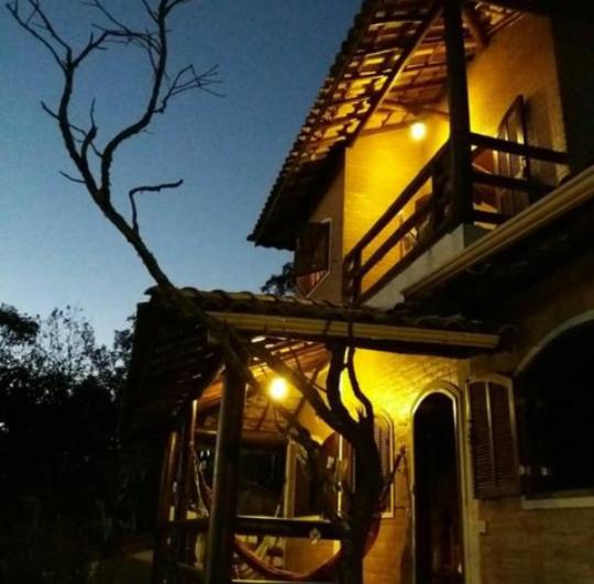 uma casa com luzes de lado à noite em Pousada Cantinho das Fadas em Conceição do Ibitipoca