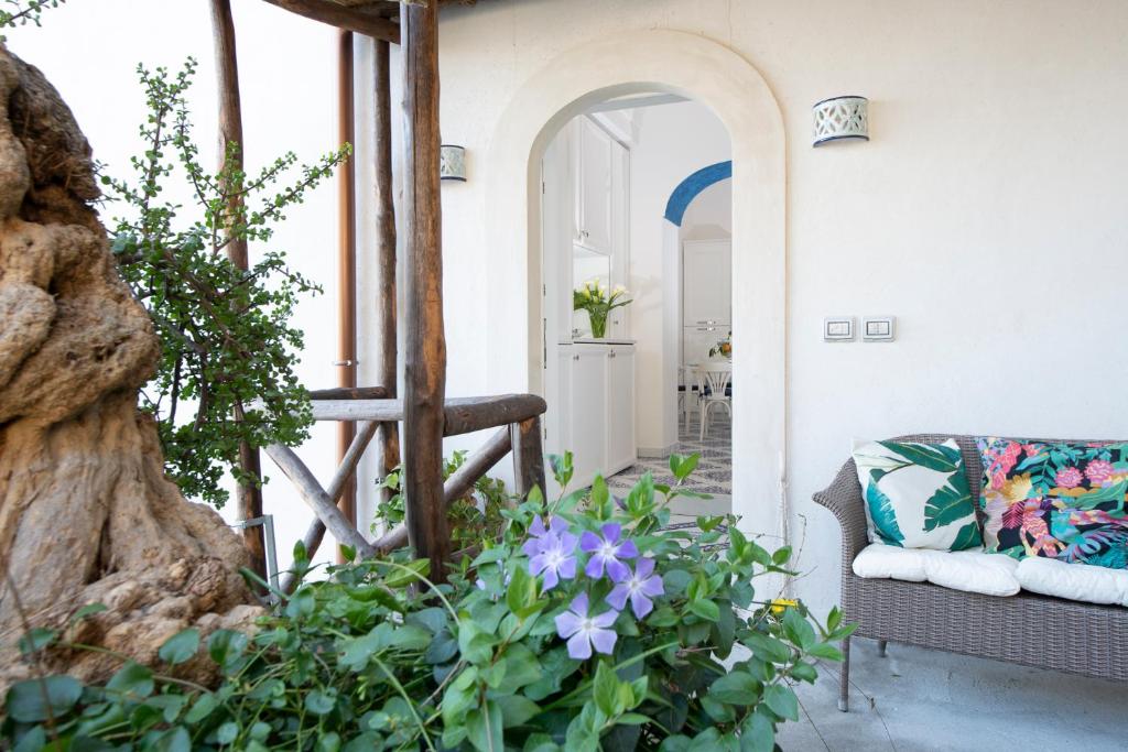 a porch with a couch and some flowers at Maison Don Rafe' in Positano