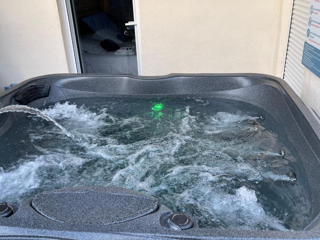 a hot tub filled with water with a green light at Le Soulier En Cévennes 4 étoiles in Saint-Martin-de-Valgalgues