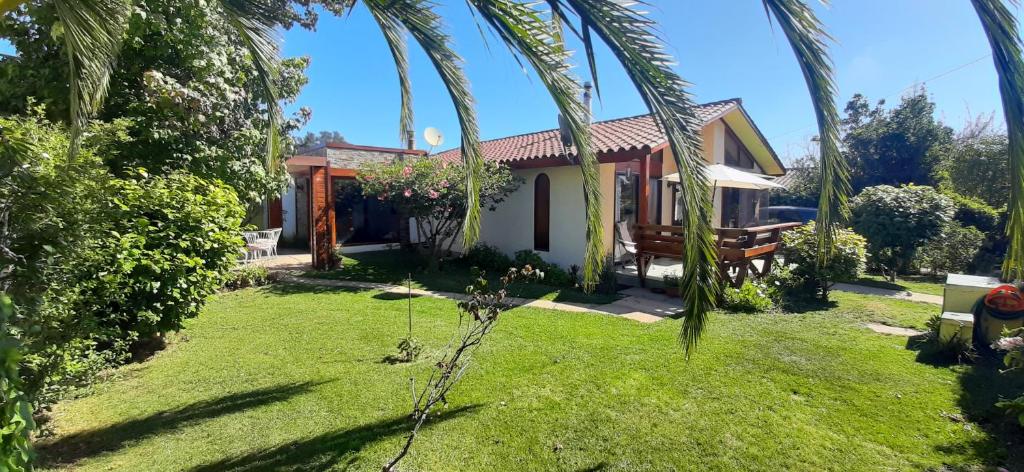 a house with a garden and palm trees at Casa en Algarrobo in Algarrobo