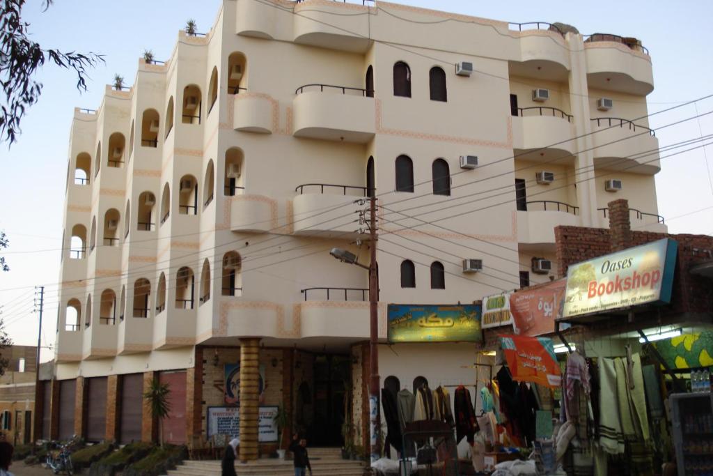 a large white building with balconies on a street at Western Desert Hotel & Safari in Bawati