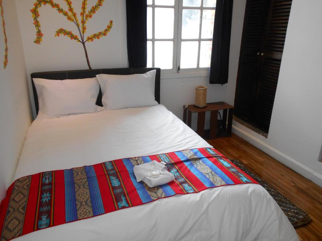a bedroom with a bed with a colorful blanket at Hotel Boutique Villa de Sant in Quito