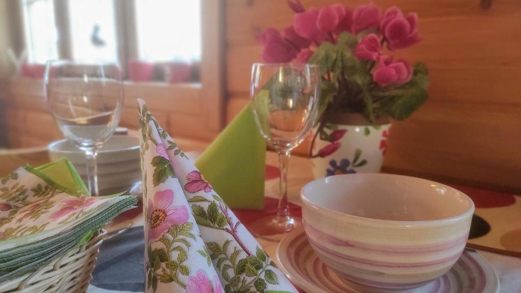 una mesa con dos copas de vino y un tazón y un plato en Holiday Cabin Kerimaa 102 en Savonlinna