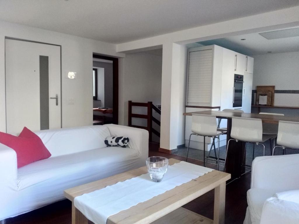 een woonkamer met een witte bank en een tafel bij Appartement "Luigi Loft" in Intragna
