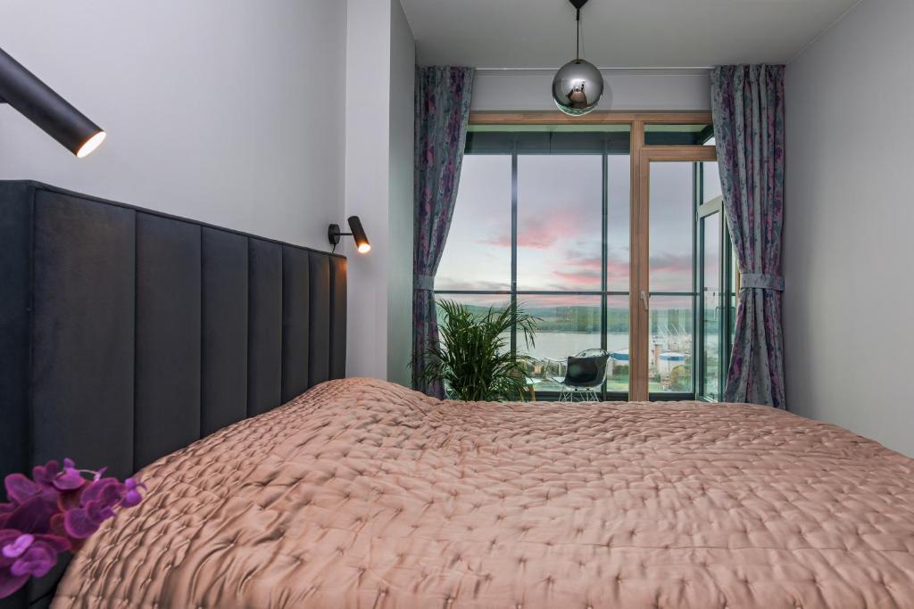 a bedroom with a large bed and a large window at Charming Apt with Spectacular Baltic Sea Views in Klaipėda