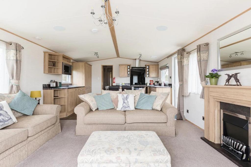 a living room with two couches and a fireplace at The Burrow in South Cerney