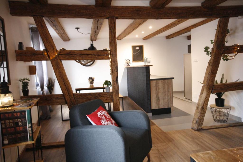 a living room with wooden beams and a blue chair at Appart'Heim in Colmar