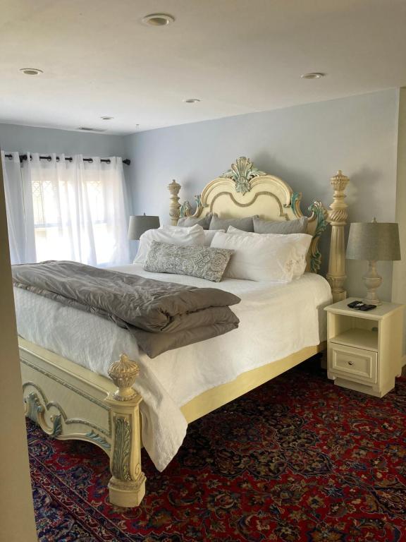 Un dormitorio con una cama grande con sábanas y almohadas blancas. en Baker&#39;s Hill Inn, en Bluefield