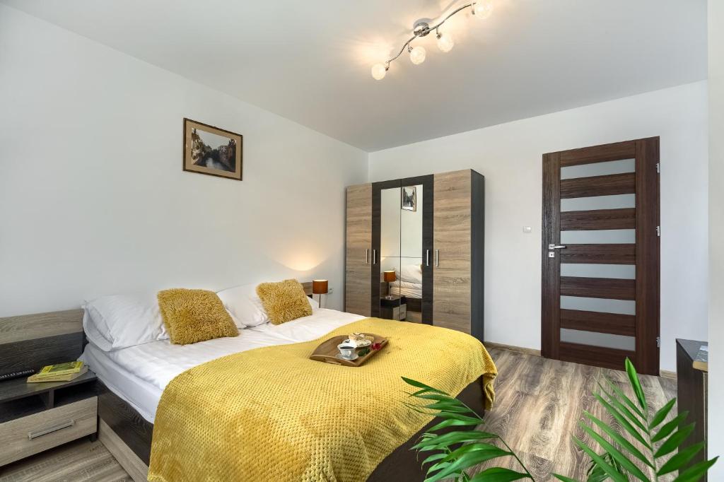 sypialnia z łóżkiem z żółtym kocem w obiekcie Apartament na Sportowej w mieście Tylicz