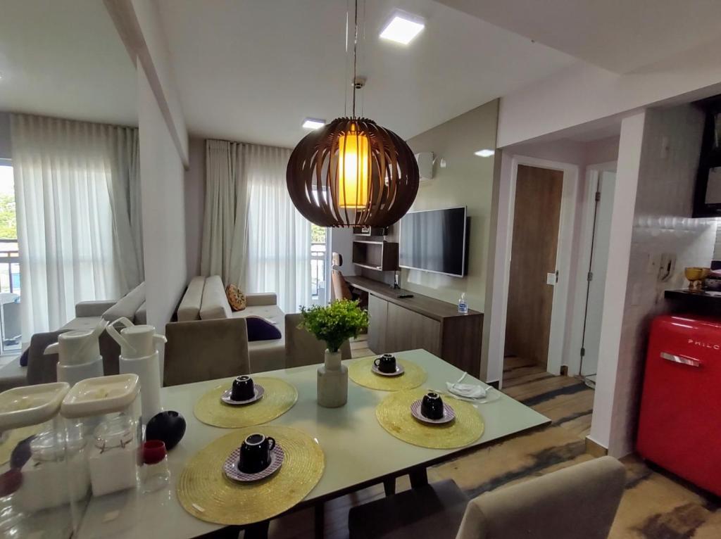 Flat 204 Smart Residence Teresina في تيريسينا: مطبخ وغرفة معيشة مع طاولة وكراسي
