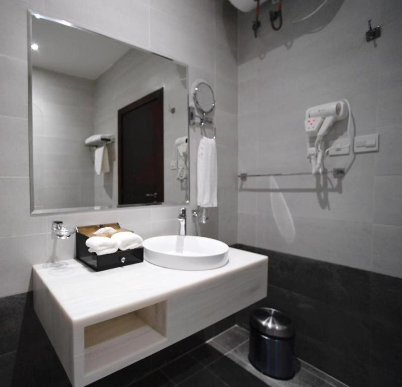 La salle de bains est pourvue d'un lavabo blanc et d'un miroir. dans l'établissement سيلين هوم الملقا, à Riyad
