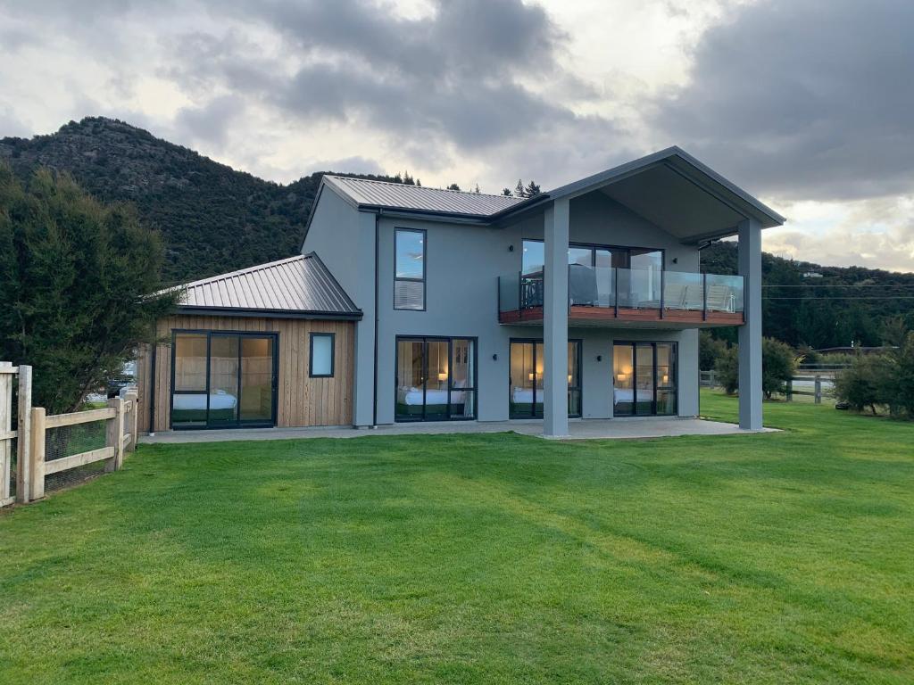 a house with a large yard with a fence at ValleyView Wanaka in Wanaka