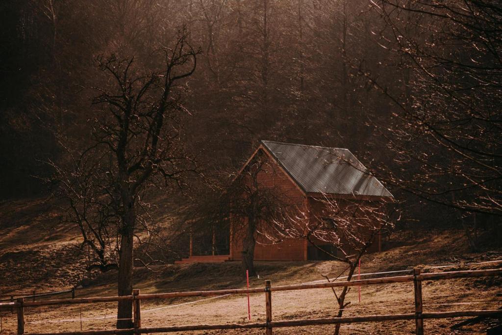 un granero rojo en la nieve con una valla en Osada Krasne - Noclegi Blisko Natury, en Bukowiec