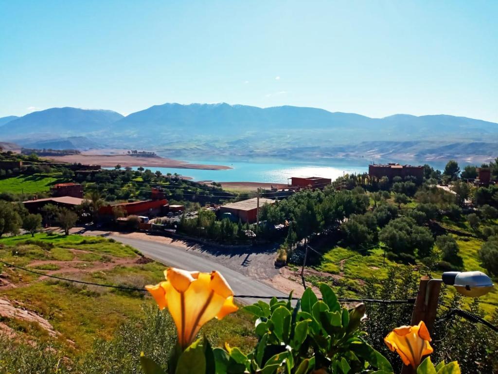 vista su un lago da una collina con fiori gialli di Abla room ad Azilal