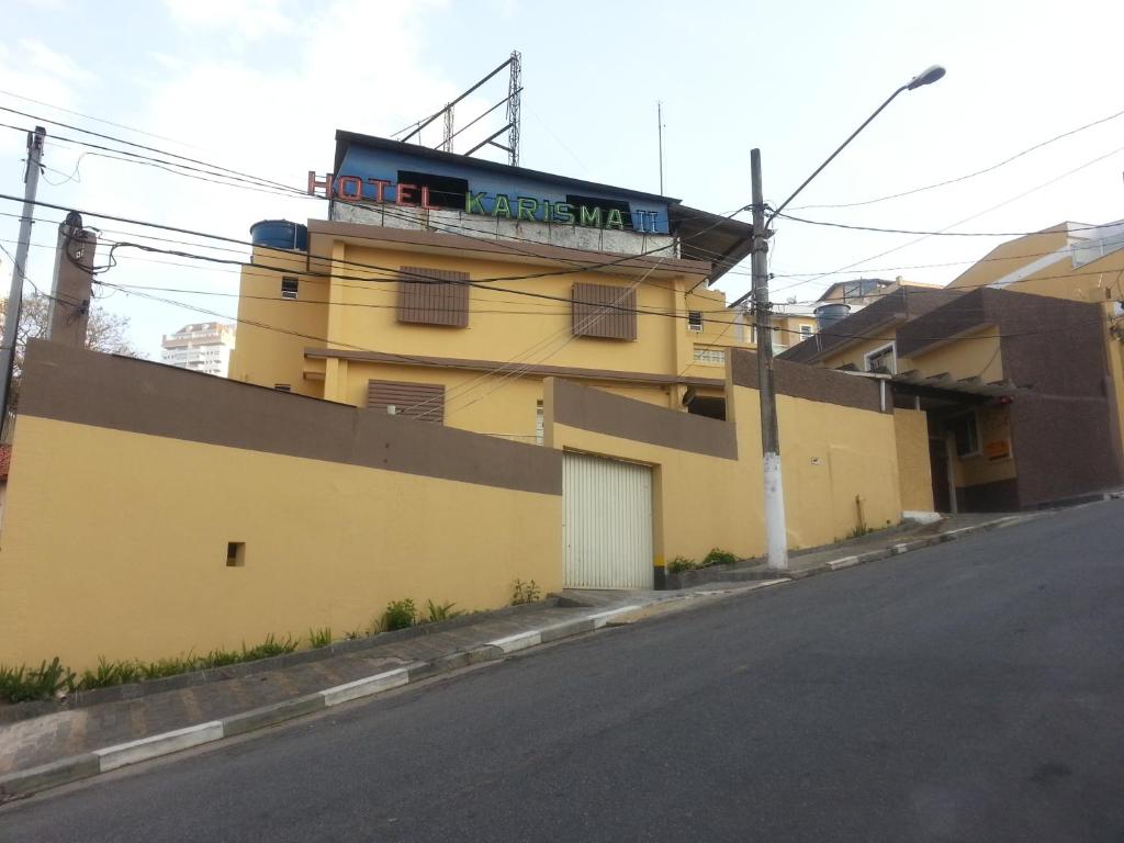 Hotel Karisma II في ساو برناندو دو كامبو: مبنى أصفر عليه علامة
