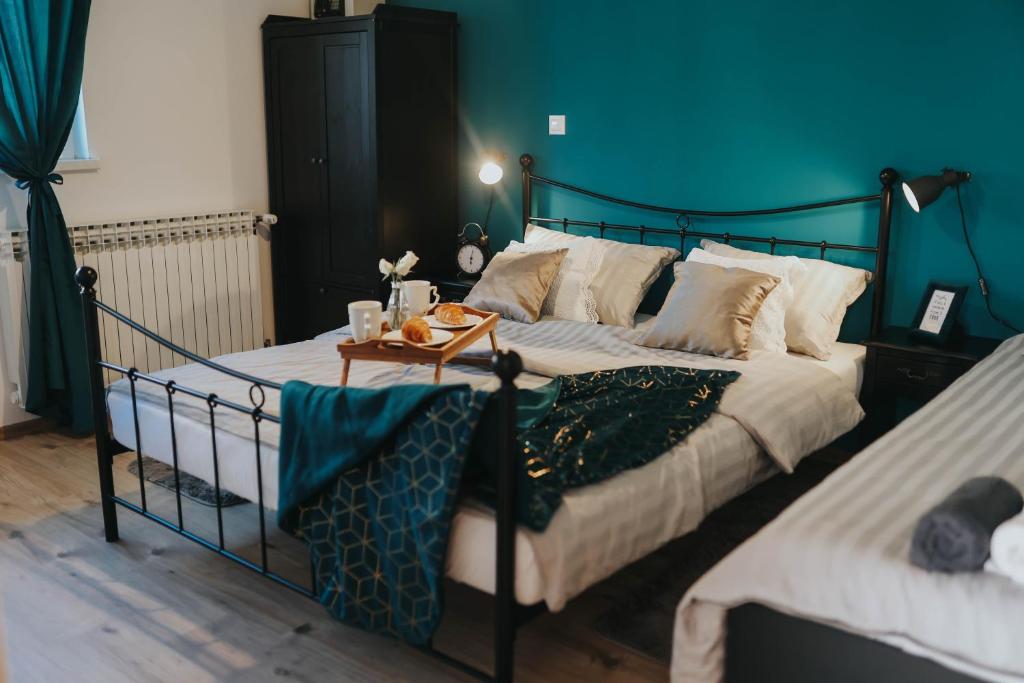 1 dormitorio con 2 camas y pared azul en Apartman Hana, en Lički Osik