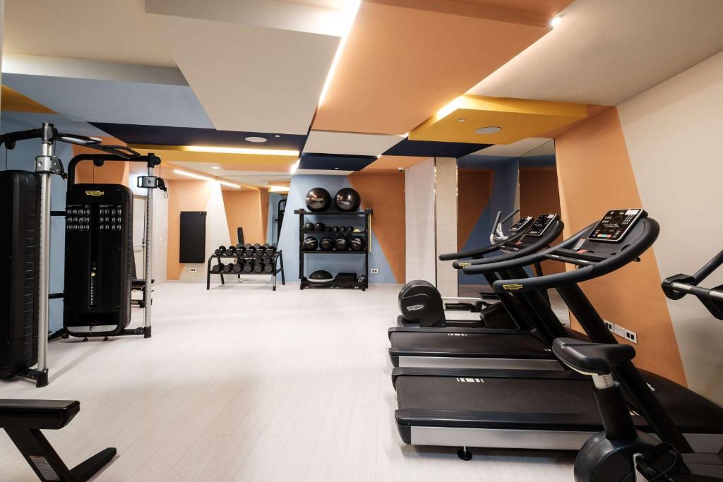 a gym with treadmills and ellipticals in a room at Hyatt Regency Malta in St. Julianʼs