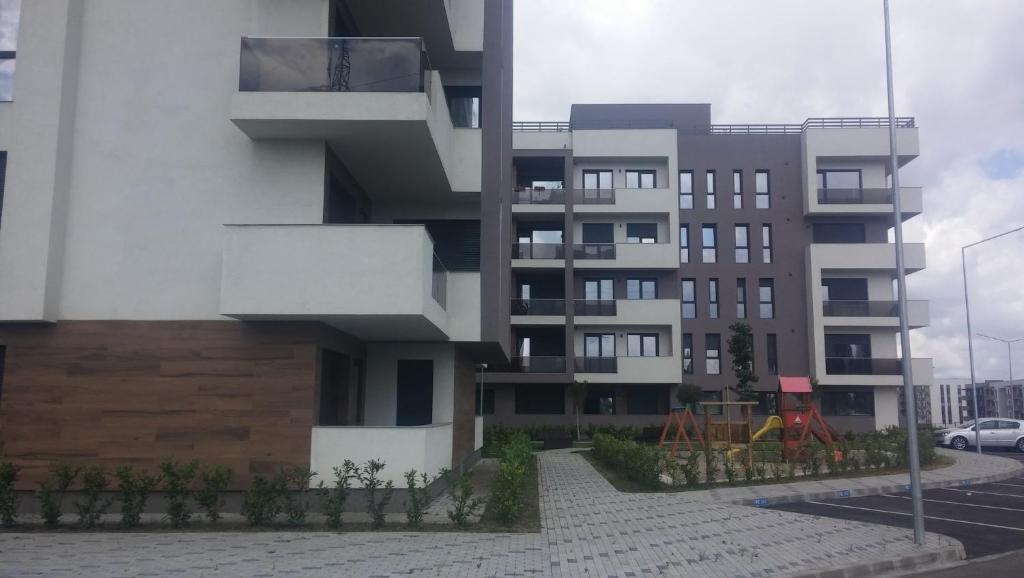 un edificio de apartamentos con un parque infantil delante de él en Apartament West, en Oradea